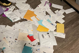 A pile of mail envelopes on the floor.